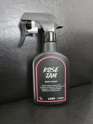 Lush Rose Jam Body Spray 200ml - En svart sprayflaska med rosa detaljer från Lush, innehållande Rose Jam Body Spray. Doften har inslag av ros och citron, och flaskan rymmer 200 ml. Enbart test sprutat vid ett tillfälle, men doften var för stark för mig.