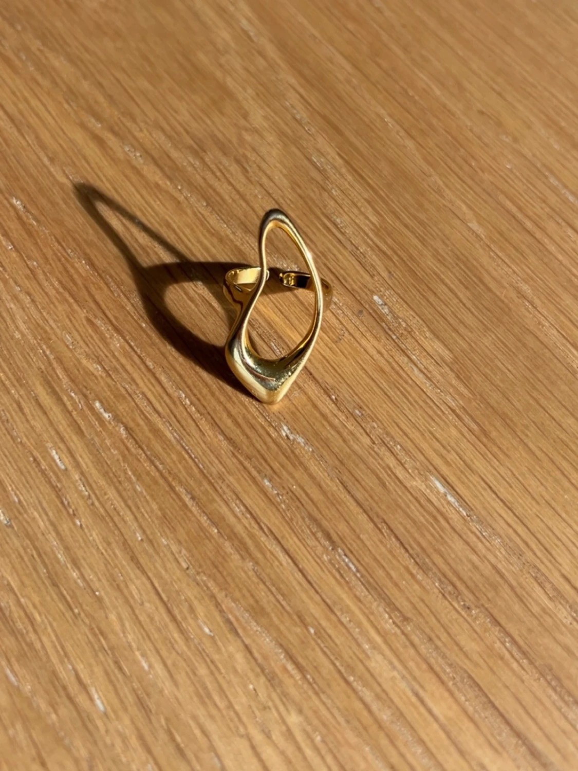 Modern guldpläterad ring i vågig form