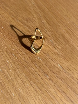Modern guldpläterad ring i vågig form - Säljer denna för den inte kommer till användning! Justerbar ring så det är bara att ändra storleken för att den ska passa! 