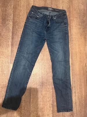 Mörkblå slim fit jeans Dressmann - Snygga mörkblå slim fit jeans från Dressmann. Jeansen har en modern passform och är tillverkade i ett slitstarkt denimtyg som passar perfekt till vardagslooken.