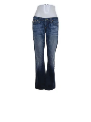 Blå jeans från True Religion - Snygga blå bootcut jeans från True Religion med slitningar och kontrastsömmar. Jeansen har klassiska fem fickor, låg midja och detaljerade bakfickor med logga. Tillverkade i denim med en cool tvätt och lätt utsvängda ben.