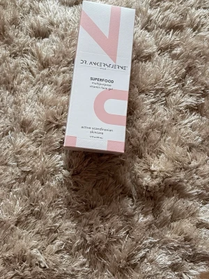 Dr. Ankerstjerne Superfood Gel - Multipurpose vitamin face gel från Dr. Ankerstjerne. En ansiktsgel med antioxidanter och vitaminer, passar alla hudtyper inklusive känslig hud. Förpackningen är vit med ljusrosa detaljer och innehåller 50 ml. Skandinavisk hudvård.