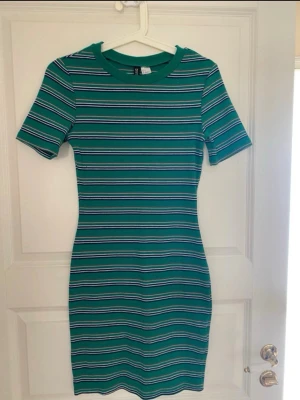 Grön randig kort klänning Gina Tricot - Snygg grön kort klänning från DIVIDED med smala horisontella ränder i vitt, svart och rosa. Klänningen har rund hals, korta ärmar och en figurnära passform. Perfekt för dig som gillar en enkel men trendig stil. Kolla gärna mina andra annonser❗️