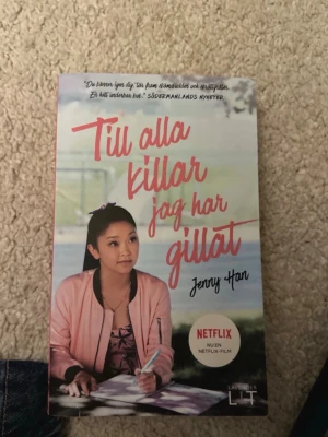 Till alla killar jag har gillat - Ungdomsroman av Jenny Han med färgstarkt omslag i rosa och blått. Boken handlar om Lara Jean som förvarar sina kärleksbrev i en hattask. Omslaget har en bild på en tjej i rosa jacka och text om Netflix-filmatiseringen.
