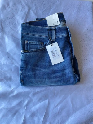 Blå jeans från T/J med klassisk passform - Säljer ett par blå jeans från T/J med klassisk femficksmodell och snygga kontrastsömmar. Jeansen har en tidlös tvätt och är tillverkade i slitstarkt denimtyg. Perfekta för dig som gillar en enkel och stilren look.Nypris runt 1300 kr! Stl w:30 L:34