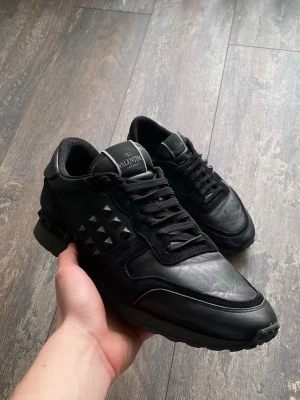 Valentino Rockrunners - Säljer ett par riktigt snygga Valentino Rockrunners i färgen svart. Dessa är väldigt välkända och snygga. Skicket är 7/10 då lite nitar är av, men de är snyggt. Storleken är 43. Priset kommer ligga på 1199kr men kan sänkas.