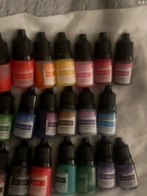 Färgpigment för naglar, 20 flaskor - Säljer ett set med små flaskor färgpigment i olika färger som röd, orange, gul, rosa, blå, grön, lila, svart och brun. Perfekt för konst, naglar eller DIY-projekt. Flaskorna har svarta skruvkorkar och tydliga etiketter med färgnamn.