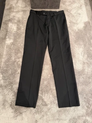Svarta kostymbyxor från Pour Homme - Snygga svarta kostymbyxor med rak passform. Mycket gott skick. Storleken är C48 och byxan är knappast använd. 
