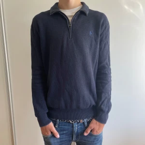 Half zip från Polo Ralph Lauren - Säljer denna mörkblå stickade tröja från Polo Ralph Lauren! Tröjan är gjord av Pima-bomull vilket gör den extra skön!  Den är i fint skick och har inga större defekter! Modellen är ca 180cm. Tveka inte på att höra av dig om du har frågor!🙌Priset är inte hugget i sten! 🪨 