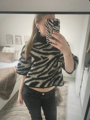 zebramönstrad polo stickad tröja - comma, - säljer en fluffig stickad tröja med zebramönster i svart och beige. tröjan har en polo krage och armarna är trekvarts, perfekt och lös i passformen, jättesnygg!!