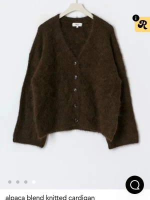 Brun fluffig kofta  - Mysig brun kofta från Gina tricot alpackablandning. Koftan har v-ringning, stora knappar framtill och en fluffig, stickad struktur. Passar Allt från S-XL beroende på vilken passform man vill ha. Orginalpris 1200kr använd fåtal gånger