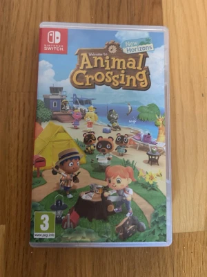 Animal Crossing: New Horizons Switch - Animal Crossing: New Horizons till Nintendo Switch. Spelet har ett färgglatt omslag med tecknade figurer på en ö, blå himmel och grönt gräs. Omslaget är av plast och spelet är i fysisk kassettform. Perfekt för dig som gillar avslappnade och kreativa spel.
