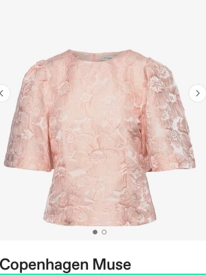 Rosa blommig blus från Copenhagen Muse - Supersöt ljusrosa blus med blommigt broderi från Copenhagen Muse. Blusen har rund halsringning, korta puffärmar och en lätt boxig passform. Materialet är strukturerat med vackra blommönster som ger en lyxig känsla.