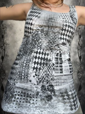 Svartvit mönstrad ärmlös linnetopp - Unik ärmlös kortklänning i svartvitt med mixade mönster som rutor, blommor och nät. Klänningen har en slim passform och är tillverkad i ett mjukt syntetmaterial. Perfekt för dig som gillar statement-plagg och vill sticka ut med coola detaljer.