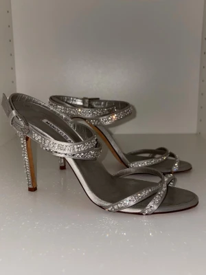 ✨ Eleganta vintageklackar från Manolo Blahnik ✨ - Superfina silvriga sandaler med gnistrande strassdetaljer – perfekta för fest, bröllop eller en glamorös kväll ✨ Klassisk och tidlös design med smal klack som verkligen lyfter vilken outfit som helst.  👠 Storlek: 39 👠 Färg: Silver med strass 👠 Skick: Vintage – använda men fortfarande i fint skick (se bilder) 👠 Nypris: ca 2000 kr  Säljes till bra pris för snabb affär! Först till kvarn 💫