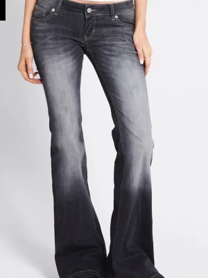 Bootcut svarta jeans med slitningar - Snygga svarta bootcut jeans med slitningar och tvättad look. Jeansen har låg midja, fem fickor och klassiska sömmar. Perfekta för en avslappnad och trendig stil.