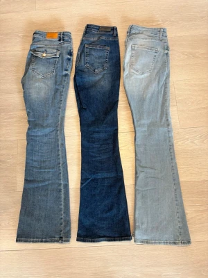 Tre par bootcut jeans i olika blå nyanser - Säljer tre par bootcut jeans. Jeansen utan knappar på fickorna är ifrån only och jeansen med knappar är ifrån vero moda. Längd 100cm.