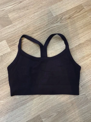 Brun sport-bh HM S - En enkel och stilren brun sport-bh med brottarrygg och bred resår under bysten. Tillverkad i ribbat stretchmaterial som ger bra stöd och komfort. Perfekt för träning. 