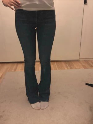 Bootcut jeans - Säljer ett par mörkblå bootcut jeans med hög midja och klassiska fickor bak. Ganska långa på mig som är 170!