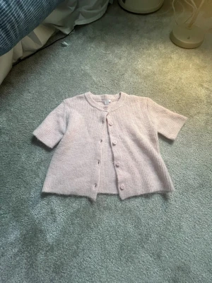 Ljusrosa ribbad kofta med kort ärm - Söt ljusrosa kofta med ribbad struktur och korta ärmar.