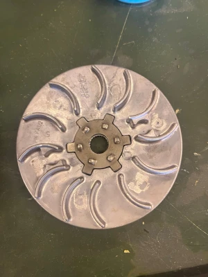 Variatorhjul i metall från Piaggio - Säljer ett variatorhjul i metall från Piaggio, perfekt för dig som mekar med mopeder eller scooters. Hjulet har ett kugghjulsmönster i mitten och flera böjda spår på ytan. Passar till olika modeller av Piaggio-fordon.