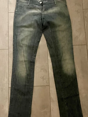Jeans från Oassian - Säljer ett par mörkblå jeans från Oassian med snygga slitningar och tvättade detaljer framtill. Klassisk femficksmodell med knapp och dragkedja. Jeansen har en modern look och passar perfekt till en avslappnad stil. Storlek 32. Tillverkade i Argentina och finns bara att köpa där. Nypris 3000kr