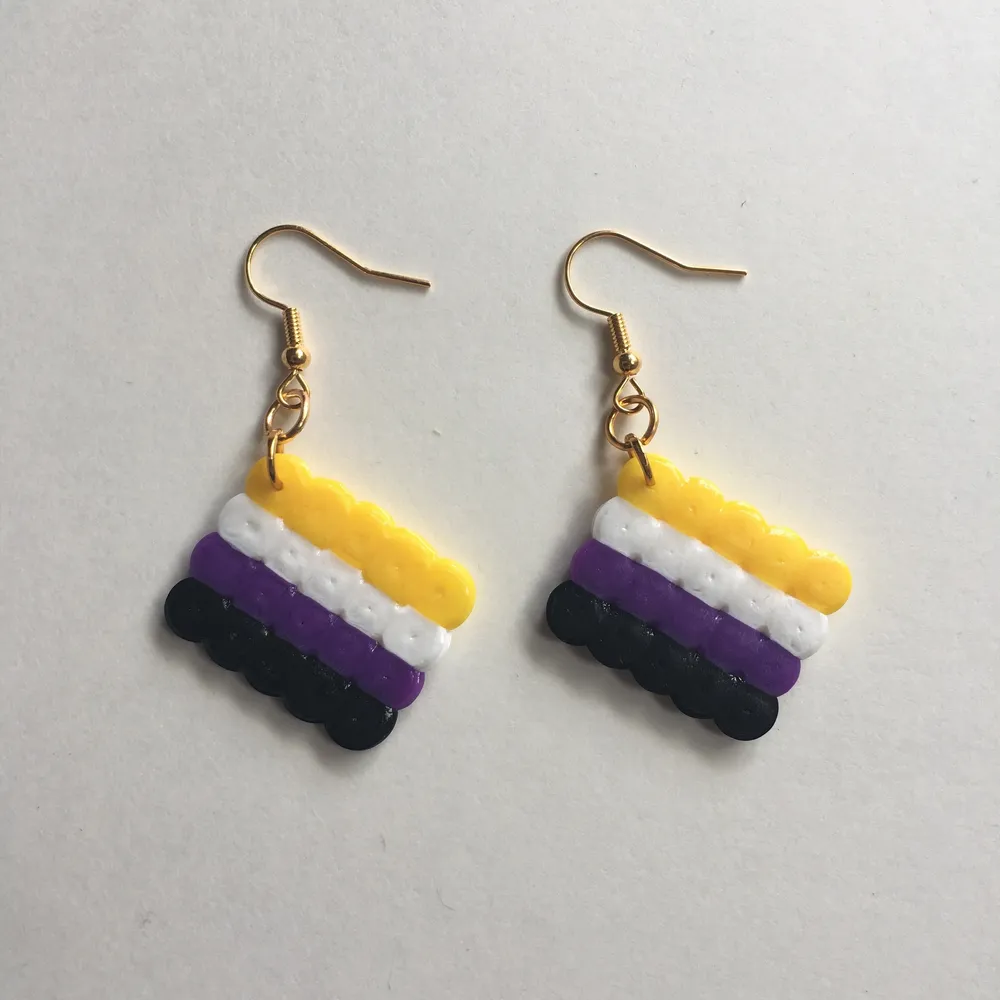 Egengjorda nickelfria örhängen av den ickebinära flaggan 💛🤍💜🖤 Andra prideflaggor finns på min sida!. Accessoarer.