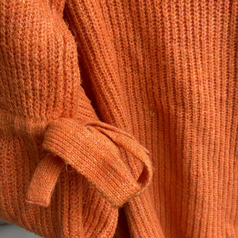 Jättehärlig stickad orange tröja från Nakd med fina detaljer såsom rosetter vid ärmarna och breda ärmar. Hur go som helst. Sparsamt använd men har en liten ögla som syns på bild 3 🧡. Stickat.