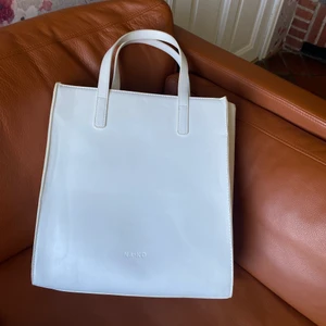 Väska - Rymlig vit väska med flera fack på insidan! Vill man inte hålla i väskan som på bilden kan man sätta dit ett längre band på insidan av väskan. Endast använd ett fåtal gånger.                      Frakt inkluderas inte i priset!