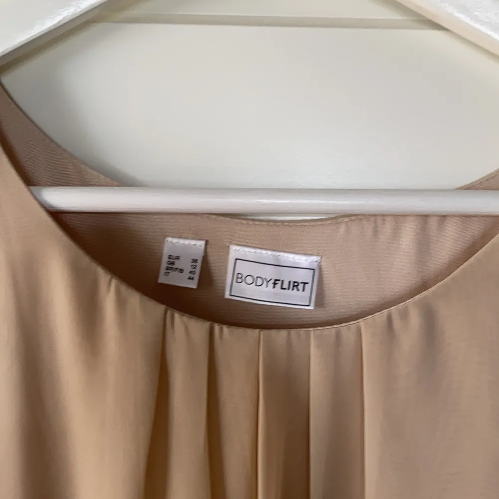 En ljus beige klänning stl38. Knappt använd. Tunt fint tyg 100% polyester tvättas i 30 grader.  Dragkedja i sidan.. Klänningar.