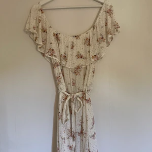 Blommig klänning - En blommig off shoulder klänning från Nelly. Endast använd en gång. Köparen står för frakt.
