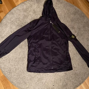 Stone Island Jacka - En jacka från Stone Island i modell Regn/Vind jacka som är i storlek MEDIUM och passar även storlek LARGE, den är helt ny och säljs pågrund av för liten storlek då jag fick den i present av en polare och vet inte om den är kopia eller riktig varav priset. Lägg vilket bud som helst så diskuterar vi fram det 🤝 (Kan sänka priset med)