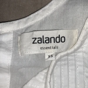 Jätte fin vit blus! - Säljer den underbart fina blusen, den sitter löst ner till och lite tajtare upp till. Den har knapp upp till i ryggen. Super gullig blus, storlek XS. Säljer då den inte kommer till användning! 