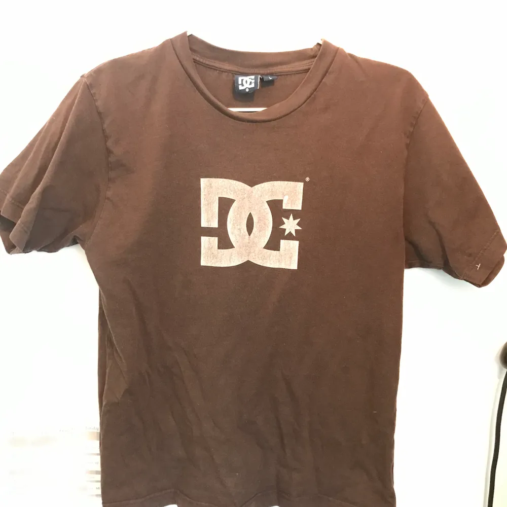 Jättesnygg brun DC tshirt i perfekt skick. Står L på lappen men passar mer som M. . T-shirts.