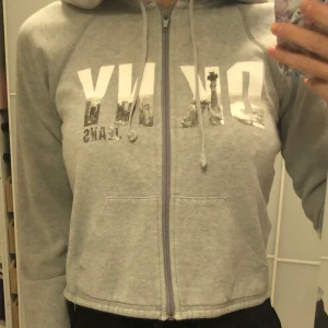 DKNY - Äkta Donna Karen New York grå super snygg hoodie med dragkedja fickor på framsidan. Midjekort. Kan fraktas mot en kostnad eller mötas 📮📍🥰
