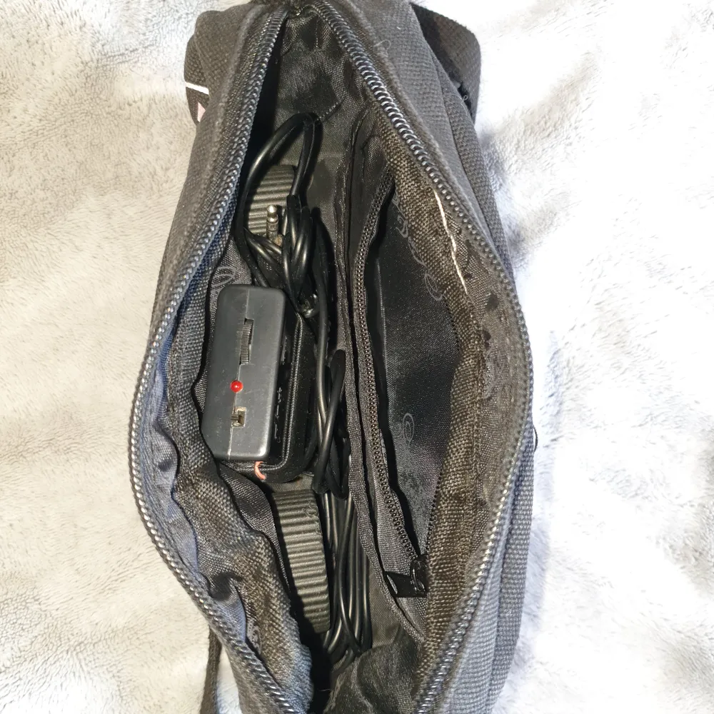 Handväska med fungerande stereo. Hur cool som helst, men kommer tyvärr inte till användning längre. Högtalarna och kablarna tar lite plats I väskan med man får plats med en hel del ändå. Två mindre fack innuti och ett på utsidan. AUX-kabel i. Väskor.