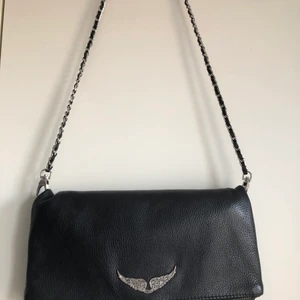 Zadig & Voltaire väska  - Säljer nu min väska från Zadig som är använd ett antal gånger men i bra skick. Köpt för 3200 kr ny och jag säljer den för 1400 kr. På tredje bilden ser ni att bandet har gått upp lite på kedjan men det går lätt att sy ihop igen.