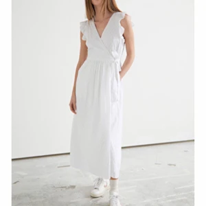 Vit klänning stories  - Vit längre klänning med volang och knyte i sidan, använd en gång på min student så i fint skick och utan fläckar. Jättefint mönster. Nypris 890kr