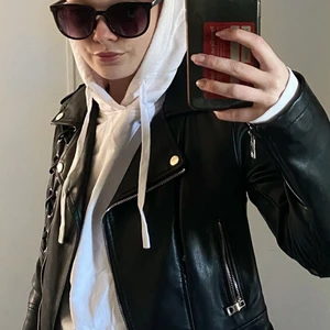 Kort skinnjacka - Jättesnygg skinnjacka med korsdetaljer! Använde den flitigt när jag köpte den men senaste året har den hängt orörd i garderoben. Frakt tillkommer!