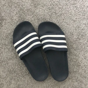 Tofflor  - Adidas tofflor i storlek 39, sitter även bra på mig som har 37 det år marinblå 