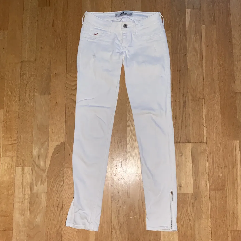 Fina lågmidjade vita hollister jeans med coola dragkedjor längst ner😍tyvärr för små för mig, storlek 0, W24 L29. Köparen står för eventuell frakt. Jeans & Byxor.