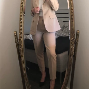 Beiga högmidjade kostymbyxor  - Beige högmidjade kostymbyor som är inköpta på New Yorker. Använda 3-4 gånger och säljes nu p.g.a att dom är för stora. 