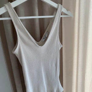 NAKD linne - Så fint ribbat linne från NAKD i en ljus beige färg. Kommer aldrig till användning, använt ca 1-2 gånger. V-ringad både bak och fram. Frakt tillkommer💞 