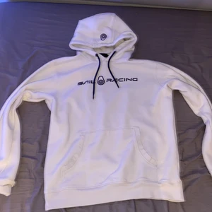 Sail racing hoodie! - Fräcsh och snygg vit Sailracing hoodie säljes. Kondition 9/10, hoodien köptes cirka för 1 år sedan för 1199kr den har använts max 10 gånger och har även inga fläckar eller smuts. Storleken är large men passar även mig som har medium