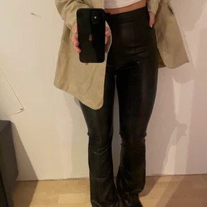Svarta skinnbyxor  - Säljer dessa svarta utsvängda byxor i läderimitation  (med fodrad insida) från NA-KD. De är i storlek 36 men passar fler storlekar då de är väldigt stretchiga. Nypris 499. Priset kan diskuteras!🥰