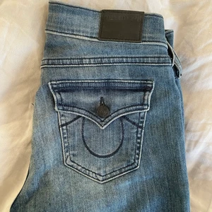 True Religion Jeans - Jättesnygga bootcut jeans från True Religion. Har klippt ett hål på knät samt slits på insidan längst ner. Nypris är 1995 kr på Zalando💘 midjemått 68 cm och innerbenslängd 85 cm