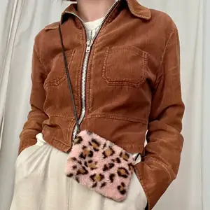 Liten fluffig rosa handväska i leopardmönstrad fuskpäls. Köpt i Tokyo och har inget märke. Aldrig använd och är i gott skick.