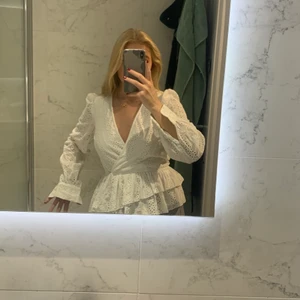 Nakd, vit, topp/blus, 36 - Säljer denna blus från NA-KD, aldrig använd utan endast prövad. Storlek 36 (lite liten i storleken men funkar på en 36 som mig). Volangen är snedskuren vilket gör att den sitter väldigt fint runt midjan. Säljer för 229 kr💖💖