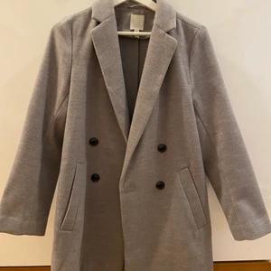 Ljusgrå kappa H&M  - FRI FRAKT! En ljusgrå kappa ifrån H&M, dam i storlek 34. Väldigt bra skick näst intill oanvänd. Passar bäst till hösten eller våren, ej fodrad. 
