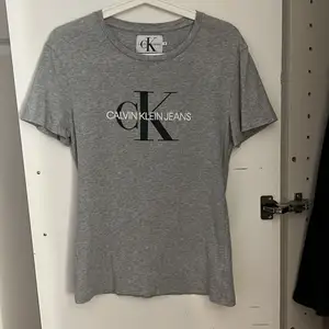 En grå T-shirt från Calvin Klein i storlek S, små hål vid lappen